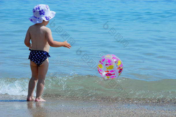 海滩上的小女孩和她的球