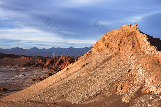 在阿塔卡马沙漠（地球上最干燥的沙漠）的月亮谷的一座山峰沐浴在暴风雨前的夕阳的余晖中