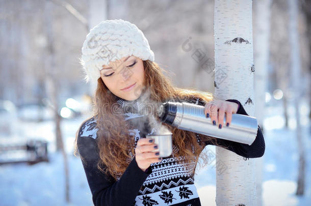 冬天，一个美丽的黑发女人从暖瓶里<strong>倒咖啡</strong>出去散步