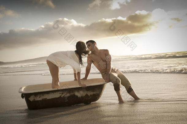 一对年轻漂亮的夫妇在海滩上和旧浴缸共度下午时光