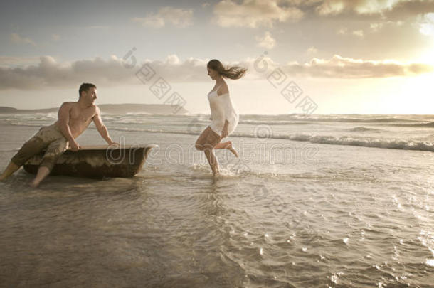 一对年轻漂亮的情侣在海滩上享受下午时光
