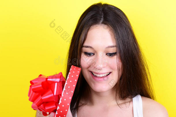 黄色背景下开心女人打开礼盒的画像