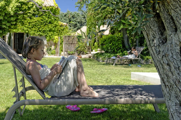 女孩在普罗旺斯的游泳池边读书