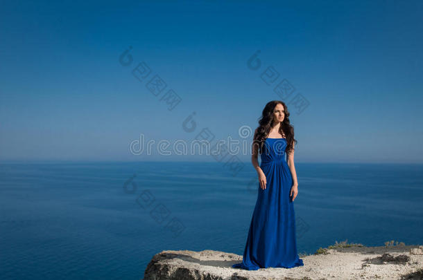 夏季肖像画。站在蓝色山崖上的美女