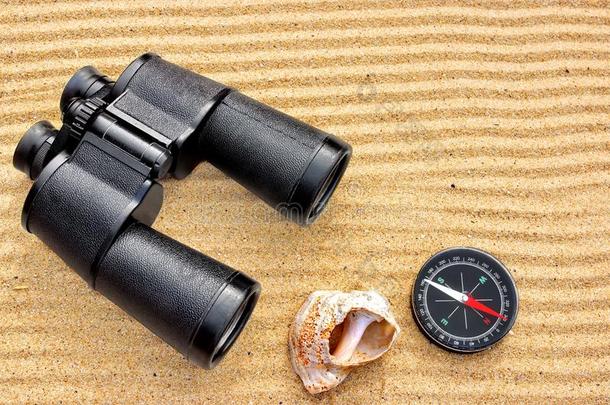 沙滩上的海洋望远镜和指南针