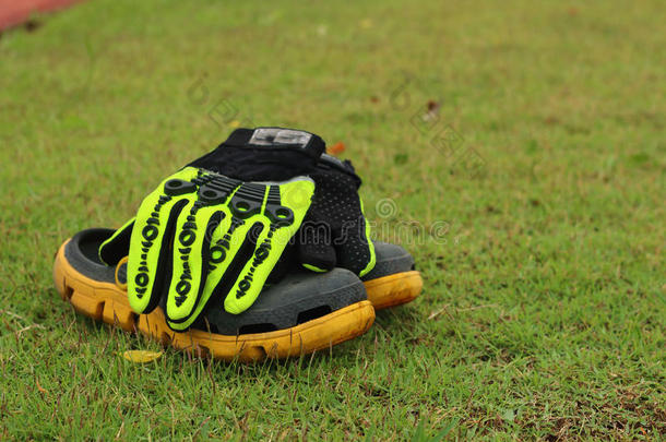 足球鞋和手套在绿草地上。