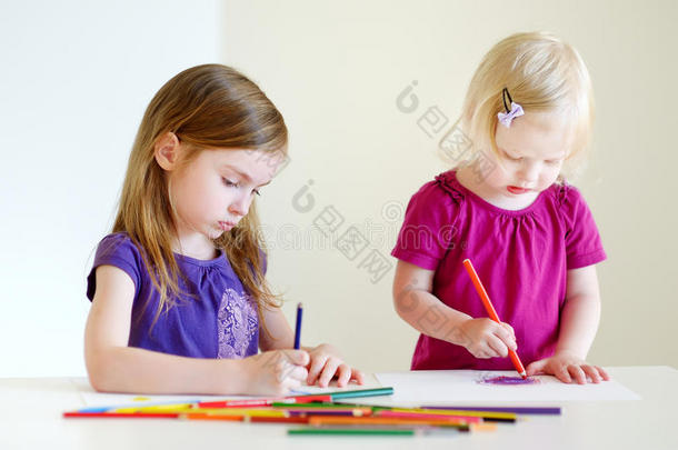 两个小姐妹用<strong>彩色铅笔画</strong>画