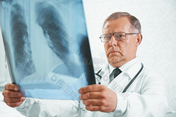 老医生检查肺部的x光片