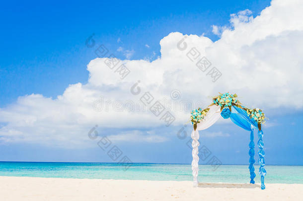 户外热带海滩上装饰有鲜花的结婚拱门