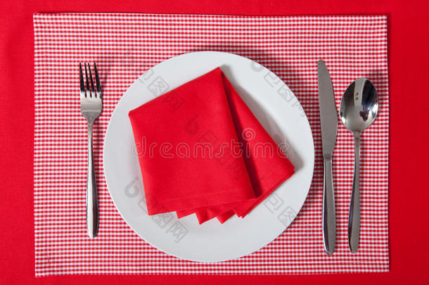 铺好的桌子-叉子和勺子放在红布和白板上