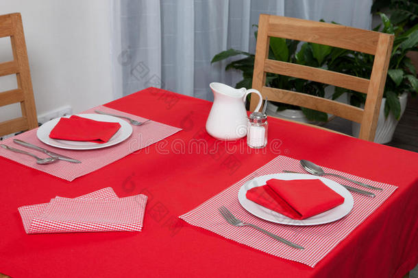 铺好的桌子-叉子和勺子放在<strong>红布</strong>和白板上