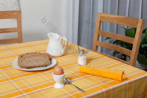 放在桌子上的叉子和勺子放在黄色和橙色的布和白色的盘子上