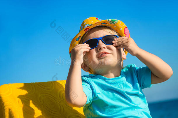 海滩上戴着太阳眼镜和帽子的男孩