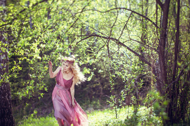 穿着仙女装的女孩在树林里散步