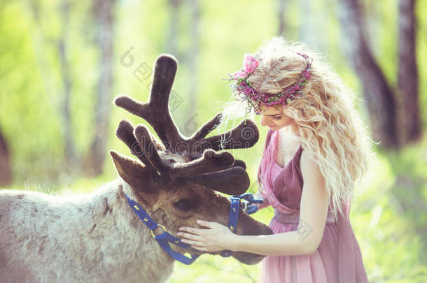 一个穿着仙女裙的女孩在驯鹿旁边的肖像