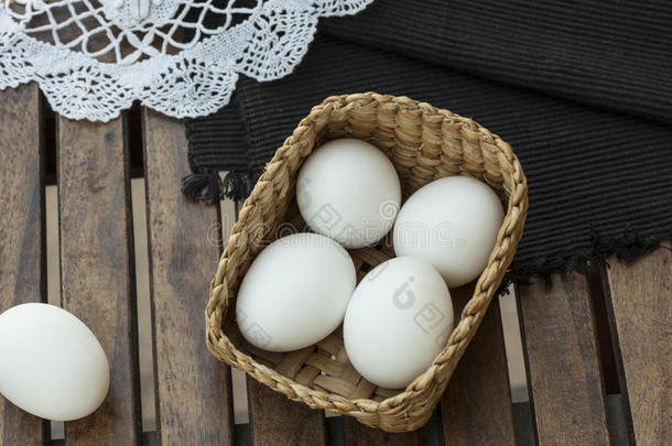 鸡蛋放在木桌上的木篮里。