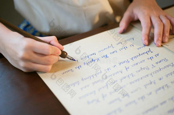 复古的<strong>效果</strong>褪去和色调的形象，一个女孩在用钢笔写纸条古色古香的手<strong>写字</strong>母。