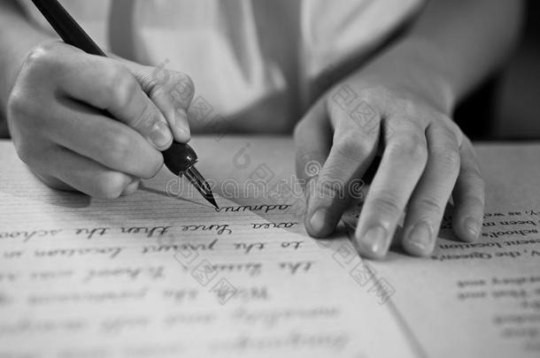 复古的效果褪去和色调的形象，一个女孩在用钢笔写纸条古色古香的手写字母。