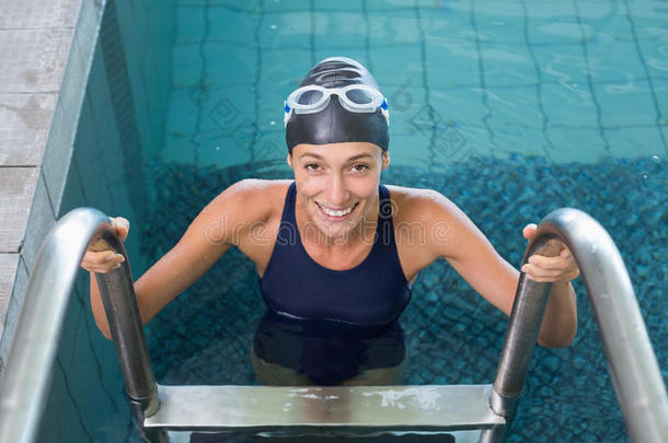 健康的游泳运动员微笑着走出游泳池