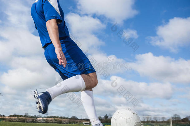穿蓝色衣服的足球运动员在球场上踢球