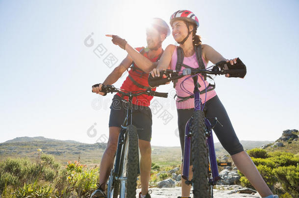 适合骑自行车的夫妇在山上四处张望