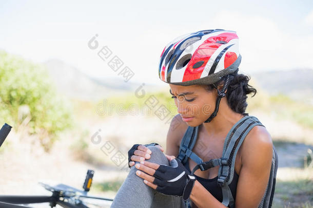 骑自行车撞车后抱着受伤膝盖的健康妇女
