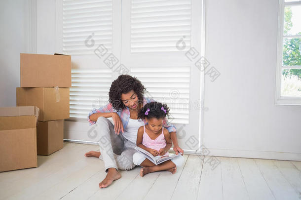 母女俩坐在地板上读故事书一