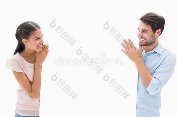 迷人的年轻夫妇微笑着举着<strong>海报</strong>