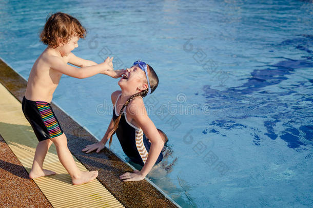 一个小女孩和小男孩在游<strong>泳池里玩耍</strong>