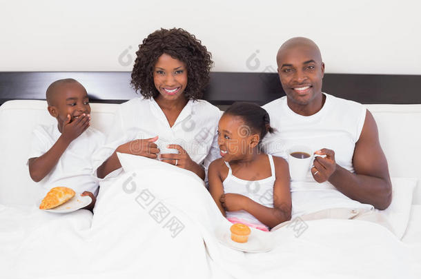 快乐的一家人在床上吃早餐