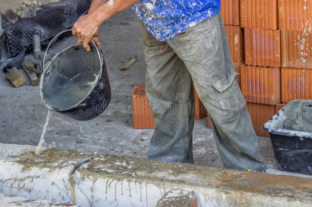 建筑工人用一桶<strong>水润</strong>湿混凝土