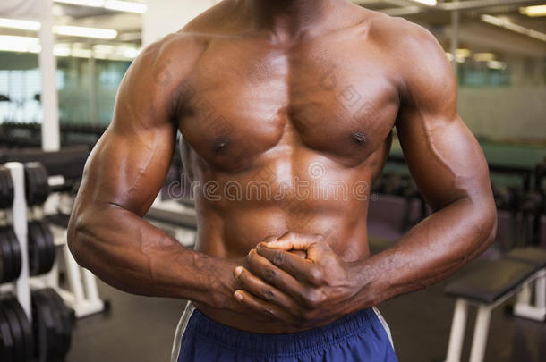 一个赤膊<strong>肌肉男</strong>在健身房的中间部分