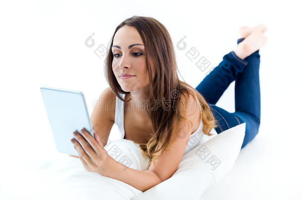 年轻女子在家拿着数码平板电脑。白色隔离。