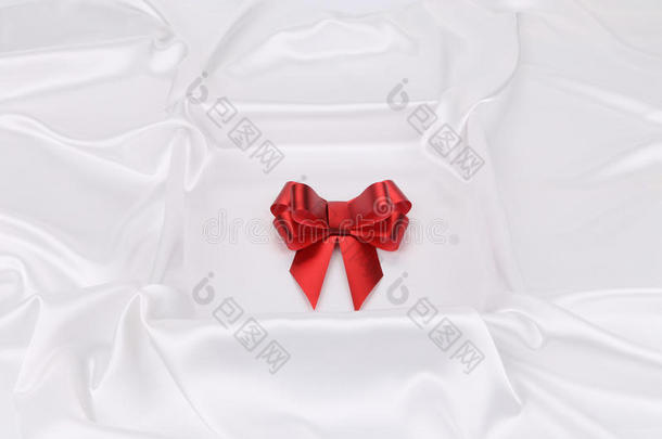 白色丝绸背景上的红色结。