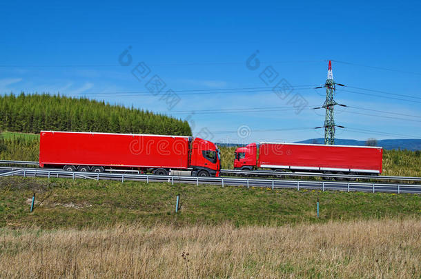 春天的风景，高速公路和迎面而来的红色卡车环绕着塔柱驶过