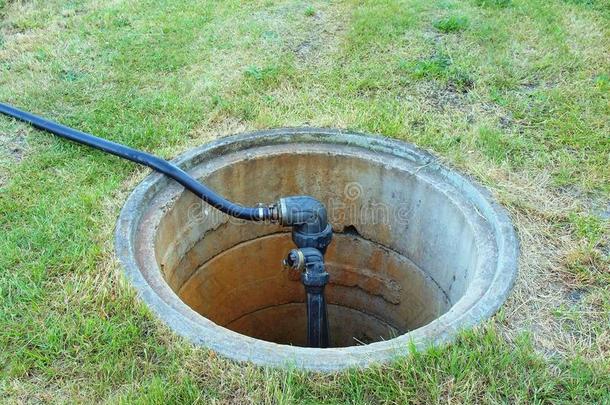 用灌溉系统主水阀和塑料软管打开混凝土渠道盖。地下混凝土管