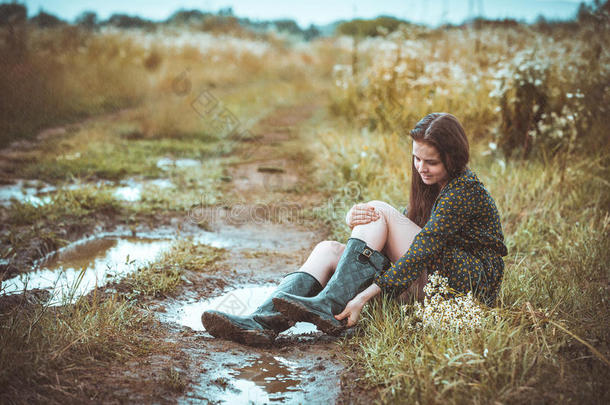 女孩坐在乡间小路上及时下起雨来