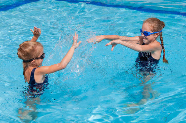两个快乐的小女孩在游<strong>泳池里玩耍</strong>