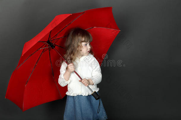 一个头发飘逸的小女孩站在伞下
