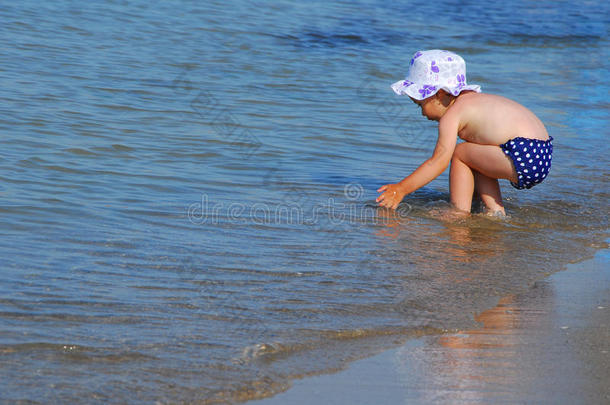 小女孩在海滩上的水里玩耍