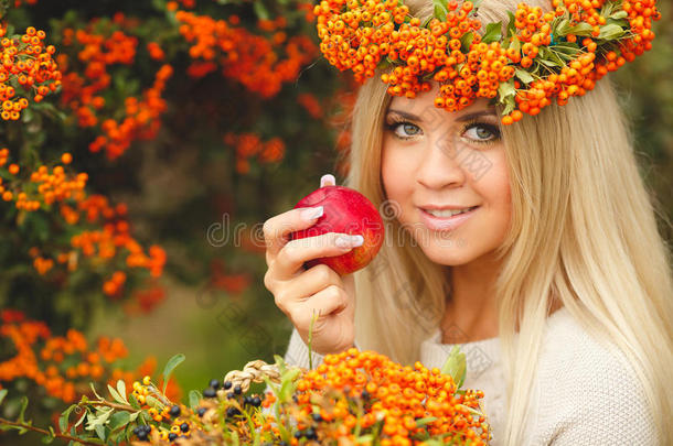 穿着橙色<strong>花环</strong>的女孩手里<strong>拿着</strong>红苹果