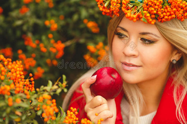 穿着橙色花环的女孩手里拿着<strong>红苹果</strong>