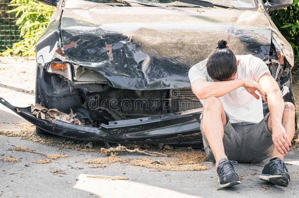 一辆撞车后，绝望的人在他那辆损坏的旧车上哭泣