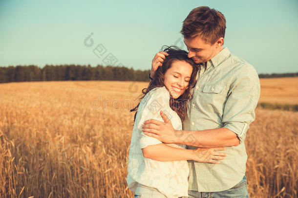 相爱的年轻夫妇户外.<strong>情侣</strong>拥抱。年轻美丽的<strong>情侣</strong>在<strong>夕阳下</strong>停留在田野上亲吻。
