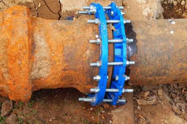 用新的蓝色阀门和新的蓝色连接件连接旧的大型饮用水管。已完成修复的管道等待覆盖