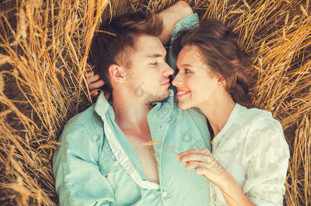 相爱的年轻夫妇户外.情侣拥抱。年轻美丽的情侣在夕阳下停留在田野上亲吻。