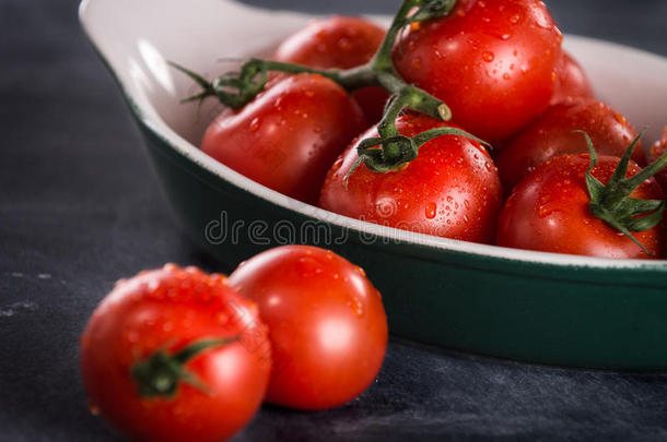 成熟的<strong>樱桃</strong>西红柿放在<strong>一个</strong>黑色背景的碗里。