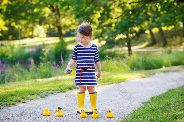 两个孩子的漂亮小女孩在玩黄色橡胶鸭子