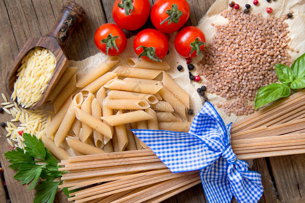 意大利面，西红柿，罗勒和欧芹，木质背景