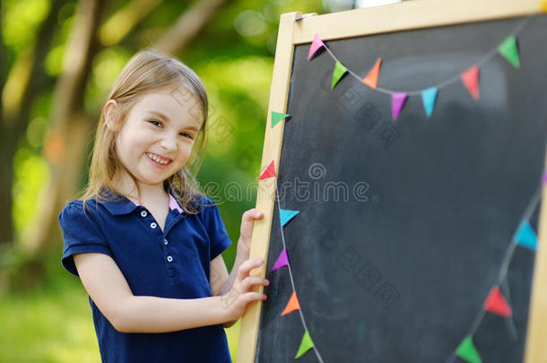 很兴奋的小女生坐在黑板旁